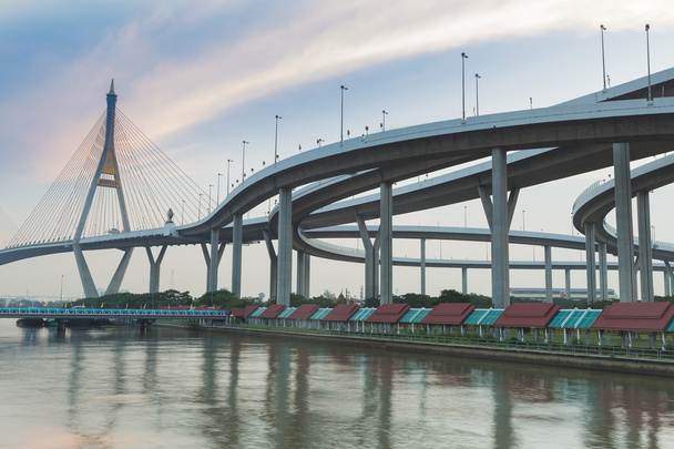 Pont suspendu relié à l'échangeur routier le long de la rivière
 - Photo, image