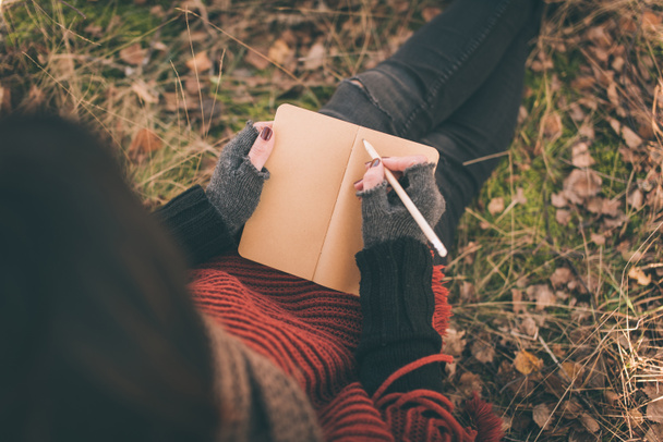 Mujer en la naturaleza escribiendo en un cuaderno
 - Foto, Imagen
