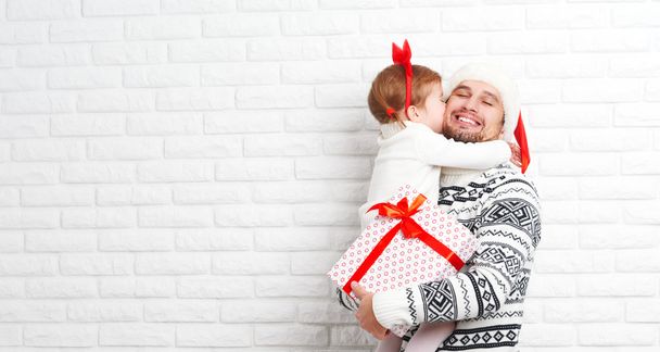 Happy family father and child with gift in Christmas kiss - Фото, изображение