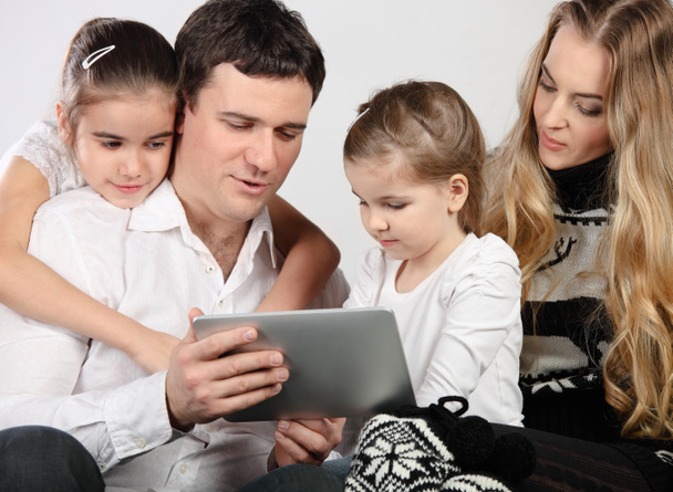 Щаслива молода сім'я використовує планшетний комп'ютер
 - Фото, зображення