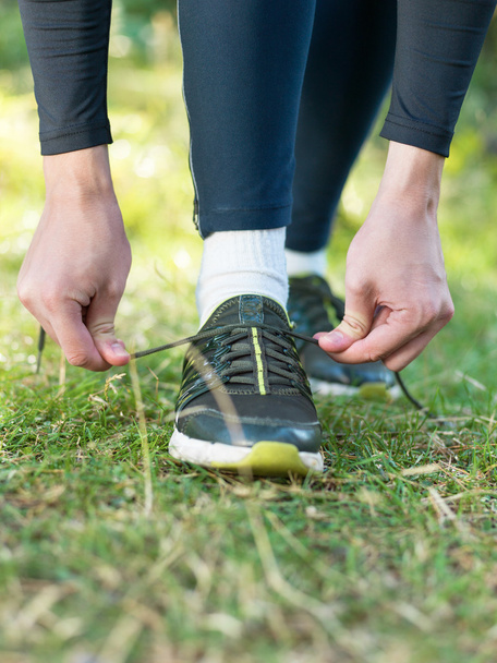 Здоровый образ жизни спортивный человек завязывая шнурки перед бегом в на
 - Фото, изображение