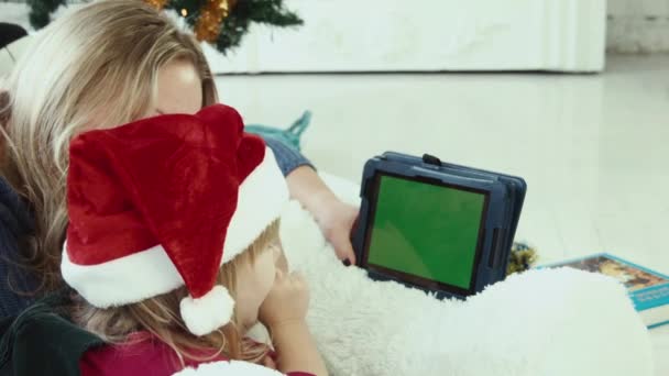 Mom reads a Christmas story with touchpad with greenscreen - Footage, Video