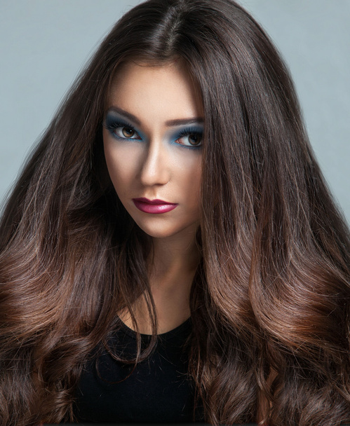 Портрет красивой молодой женщины с длинными каштановыми волосами
 - Фото, изображение
