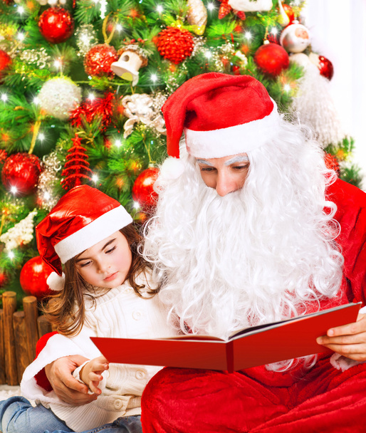 Little girl with Santa read book - Photo, Image