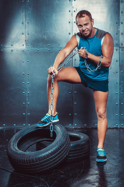 Sportovci. přizpůsobit malestands s jednou nohou na Železný řetěz a slzy, koncept fitness cvičení sílu energie. - Fotografie, Obrázek