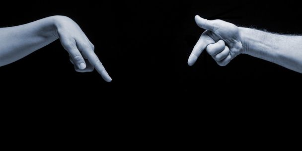 Man and woman hands pointing on empty copy space on black background. - Фото, изображение