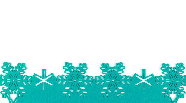 Ασυνήθιστο σχέδιο Χριστούγεννα φόντο με τυρκουάζ νιφάδες χιονιού και αντίγραφο χώρου σε άσπρο φόντο - Φωτογραφία, εικόνα