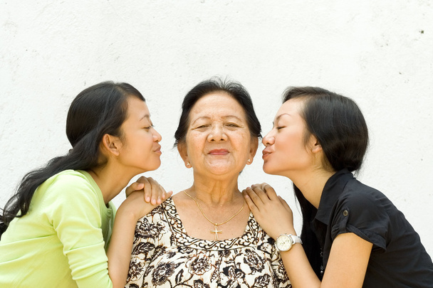 dwie wnuczki całować ich babcia - Zdjęcie, obraz