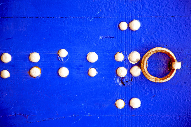 ржавый гвоздь грязный в голубой двери дерева и Марокко стук
 - Фото, изображение