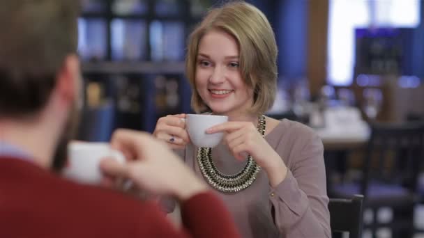 Young couple sitting in a cafe drinking coffee and tea - Záběry, video