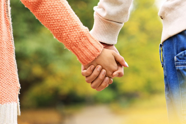 пара, держащаяся за руки в парке - Фото, изображение
