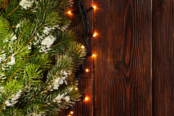 Christmas tree branch en lichten op hout - Foto, afbeelding