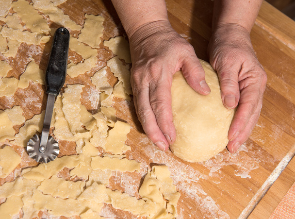 Жінка замінює тісто на столі на кухні
 - Фото, зображення