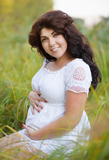 Piękna kobieta w ciąży w naciągnąć sukienka poza - Zdjęcie, obraz