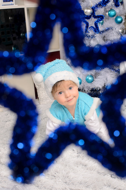 το παιδί για τα Χριστούγεννα που ταιριάζουν μέσα από διακοσμητικό αστέρι - Φωτογραφία, εικόνα