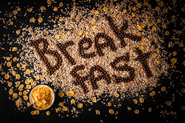 Breakfast word made by chocolate crispy ball on the muesli background - Foto, Bild