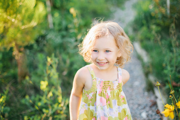 Portrait of a little girl walking in the garden - Foto, imagen