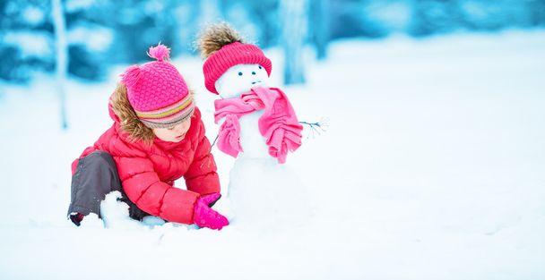 счастливая девочка со снеговиком на зимней прогулке
 - Фото, изображение