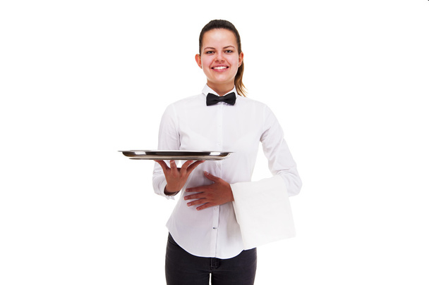Молодая женщина в форме официанта держит поднос изолирован над белой Б
 - Фото, изображение