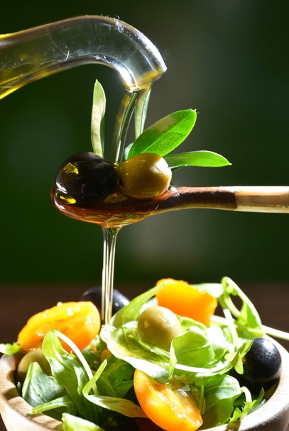 Olive oil falling on two olive with olive leaves - Valokuva, kuva