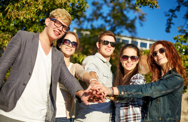ryhmä opiskelijoita tai teini-ikäisiä kädet päällä
 - Valokuva, kuva