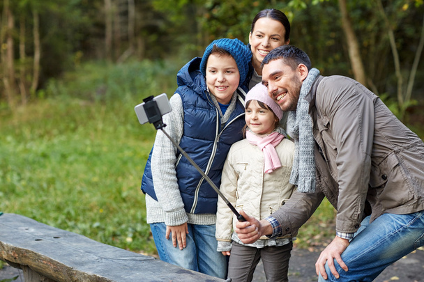 happy family with smartphone selfie stick at camp - Fotografie, Obrázek