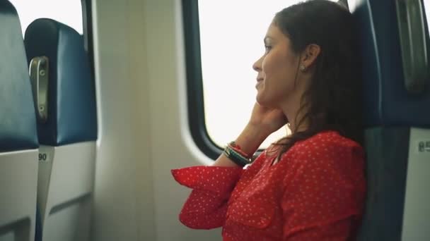 Žena, příjem hovoru a mluví na mobil uvnitř jedoucího vlaku - Záběry, video
