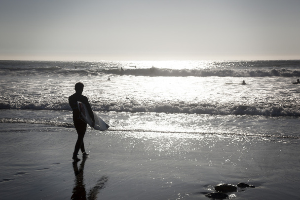 Серфер прогуливается по пляжу
 - Фото, изображение