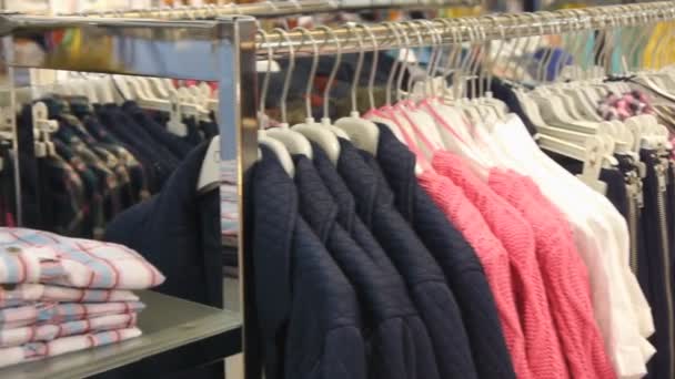 Άποψη πανοράματος ρούχα σε κρεμάστρες στο κατάστημα - Πλάνα, βίντεο