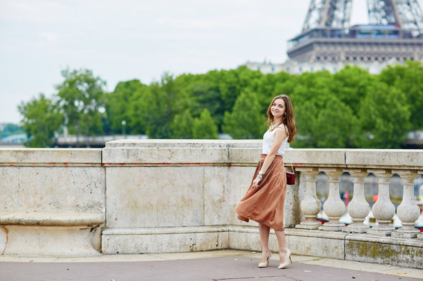 Beautiful young Parisian woman near the Eiffel tower - Zdjęcie, obraz