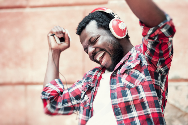 African American man listening music with headphones outdoors - Foto, Imagem