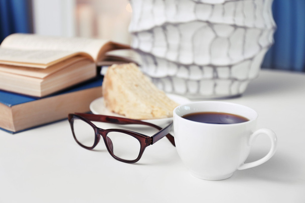 Cup of coffee with books on table in room - Photo, image