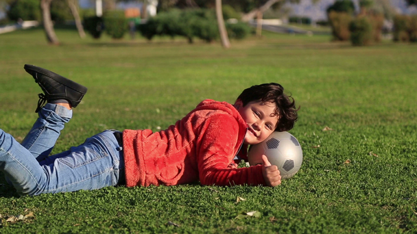 Portrét šťastné dítě s míčem úsměv na kameru - Záběry, video