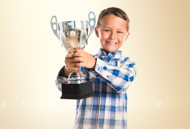 Niño sosteniendo un trofeo
 - Foto, imagen
