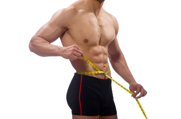 Hombre musculoso midiendo sus músculos - Foto, imagen