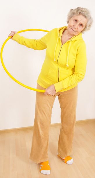 Granny doing gymnastic with hula-hoop - Foto, afbeelding
