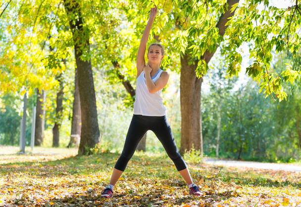 beautiful caucasian woman doing exercise outdoor in a park - Photo, image