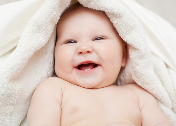 Un hermoso bebé sonriente envuelto en edredón
 - Foto, Imagen