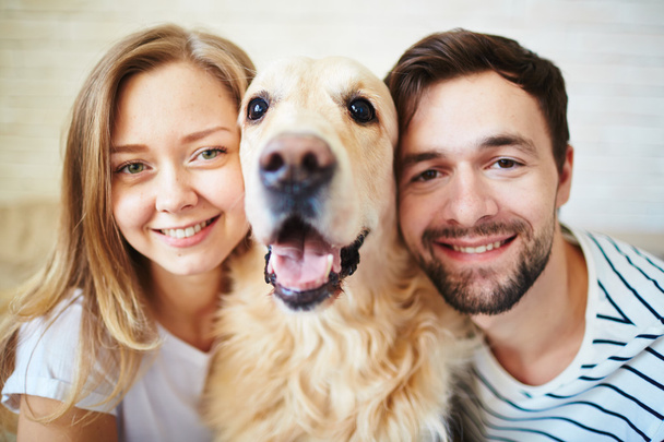 couple looking at camera with dog - Photo, Image