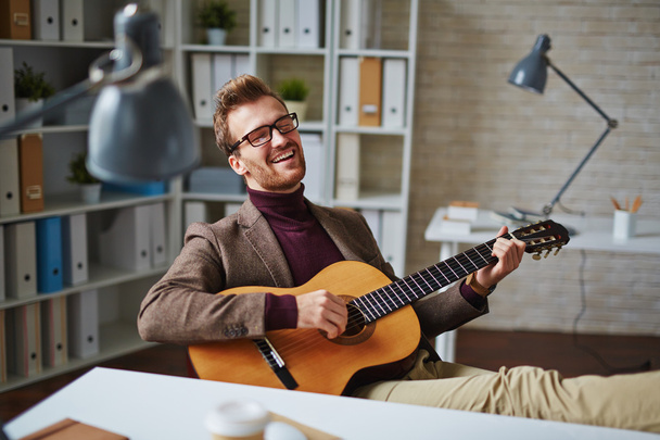 businessman playing the guitar  in office - Foto, imagen