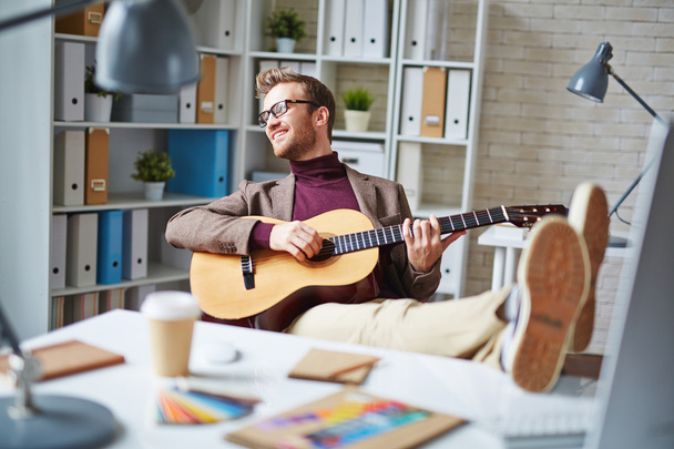 businessman playing the guitar in office - Photo, Image