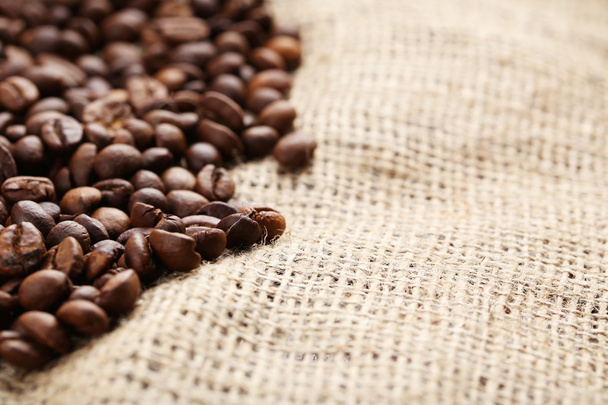 Roasted coffee beans on a sack - Фото, зображення