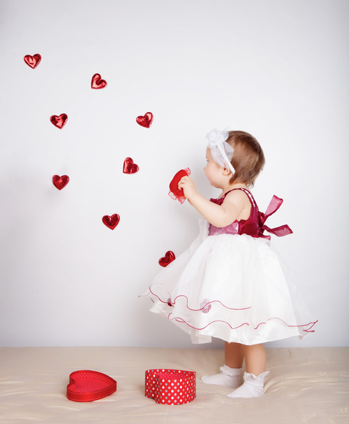 Little girl with flying hearts in studio - Foto, Imagem