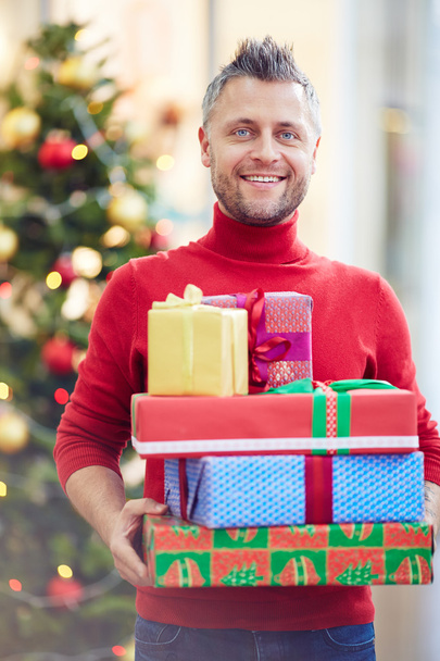 hombre sosteniendo cajas de regalo en el centro comercial
 - Foto, imagen