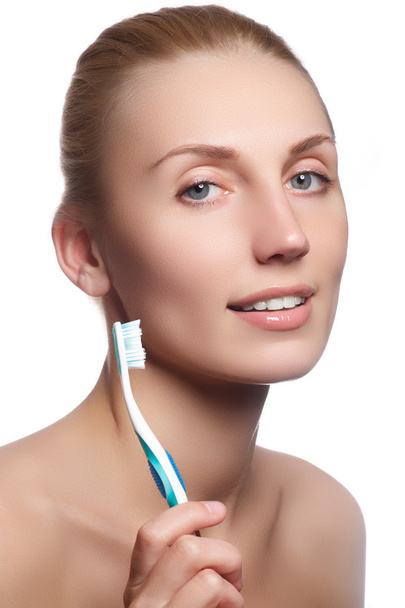 Beautiful woman with toothbrush. Dental care background. Closeup on young woman showing toothbrush. Beautiful young woman holding a toothbrush in hand - Φωτογραφία, εικόνα