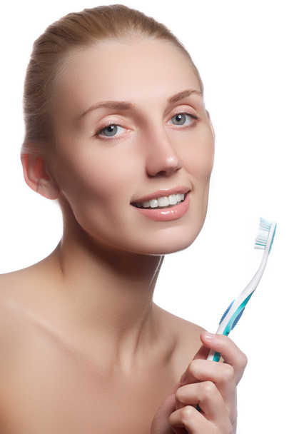 Beautiful woman with toothbrush. Dental care background. Closeup on young woman showing toothbrush. Beautiful young woman holding a toothbrush in hand - Fotoğraf, Görsel