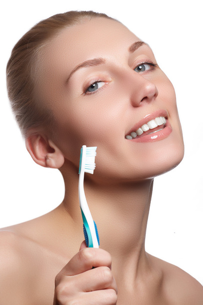 Beautiful woman with toothbrush. Dental care background. Closeup on young woman showing toothbrush. Beautiful young woman holding a toothbrush in hand - Foto, Imagem