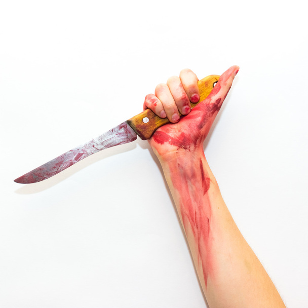 female hand with bloody steel knife with a wooden handle on a white background to the topic of Halloween - Foto, imagen