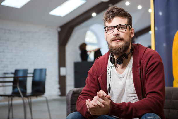 Hipster in glasses with beard sitting on sofa - Foto, imagen