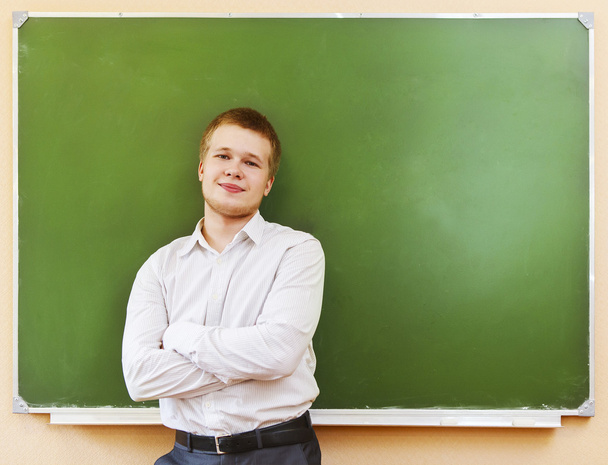 Student standing near the blackboard in the classroom - Photo, Image
